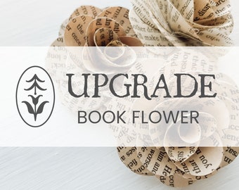 Puede incluir: Flores de papel hechas a mano con páginas de libros. Las flores están dispuestas en forma circular, con texto visible del libro. La imagen incluye el texto "UPGRADE BOOK FLOWER" y un logotipo de una flor estilizada.