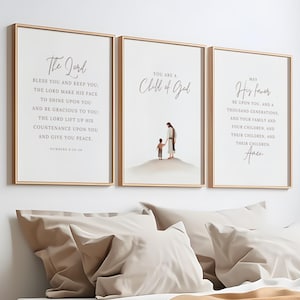 Könnte beinhalten: Drei gerahmte Kunstdrucke mit goldenen Rahmen. Die Drucke zeigen inspirierende Zitate und Illustrationen. Der erste Druck enthält Text aus Numeri 6:24-26. Der zweite Druck lautet "You are a Child of God" mit einer Illustration. Der dritte Druck sagt "May His favor".