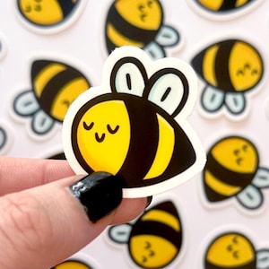 May include: A sheet of stickers featuring multiple cartoon bees with black and yellow stripes and white wings. The bees have closed eyes and smiling faces.