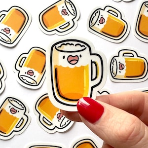 May include: A collection of cartoon beer mug stickers. The stickers feature a smiling beer mug with a handle, filled with golden beer and white foam. The stickers are outlined in black and have a white background.