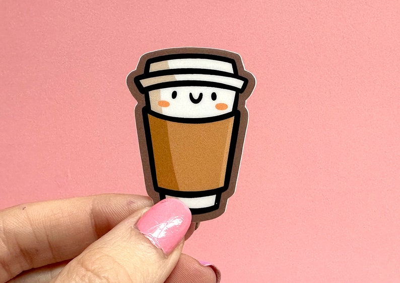 May include: A brown and white coffee cup sticker with a smiling face. The sticker is on a pink background.