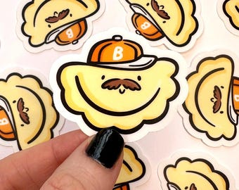 Puede incluir: Un conjunto de pegatinas coloridas con dibujos animados de pierogis que llevan gorras de béisbol. Los pierogis tienen caras sonrientes y bigotes. Las pegatinas están impresas en papel blanco.