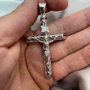 Op de afbeelding: Zilveren kruis hanger met een gedetailleerd ontwerp en de inscriptie "INRI" op de dwarsbalk.