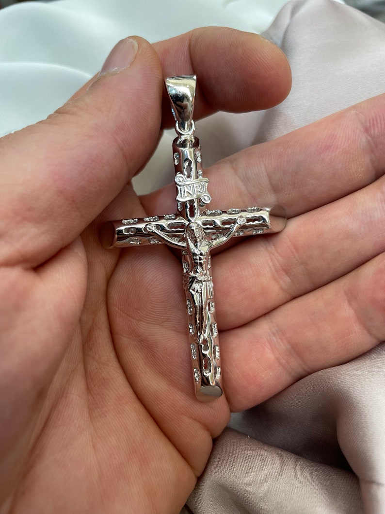 Op de afbeelding: Zilveren kruis hanger met een gedetailleerd ontwerp en de inscriptie "INRI" op de dwarsbalk.