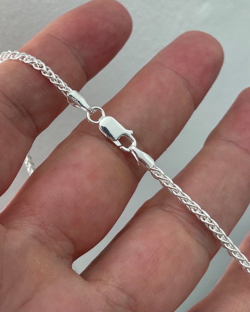 Pu&ograve; includere: Una collana a catena d'argento con un design a catena di corda. La catena &egrave; lunga circa 50 cm e ha una chiusura a moschettone.