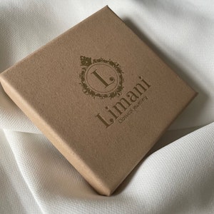 May include: A brown cardboard box with a gold logo that says "Limani Classical Jewellery".