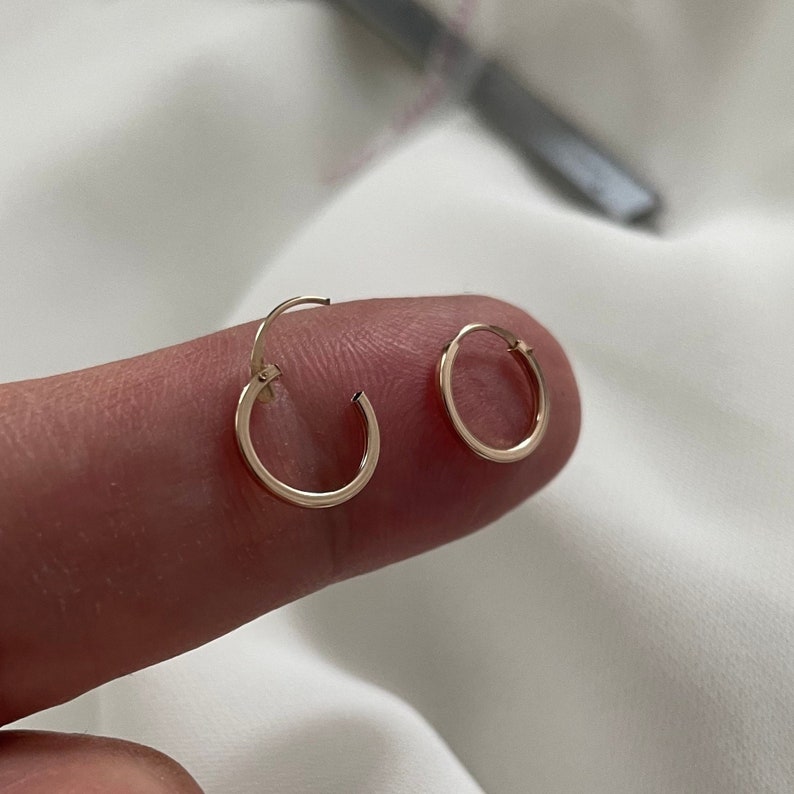 May include: A pair of small gold hoop earrings. The earrings are simple and delicate, and they would make a great everyday accessory.