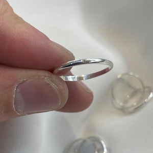 Könnte beinhalten: Eine weiße Keramik-Tasse mit schwarzem Henkel und dem Text "But First, Coffee" in fetter, schwarzer Schrift. Die Tasse steht vor einem neutralen Hintergrund, der ihr schlichtes Design hervorhebt. Die Tasse ist etwa 10 cm hoch.