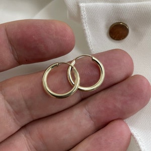 Op de afbeelding: Een paar gouden creolen. De oorbellen zijn simpel en klassiek en zouden een geweldige aanvulling zijn op elke sieradencollectie.
