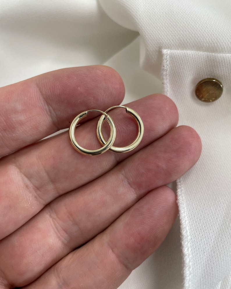 Op de afbeelding: Een paar gouden creolen. De oorbellen zijn simpel en klassiek en zouden een geweldige aanvulling zijn op elke sieradencollectie.