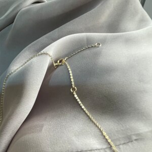 May include: A gold chain necklace with a lobster clasp closure. The chain is made of small, linked circles.