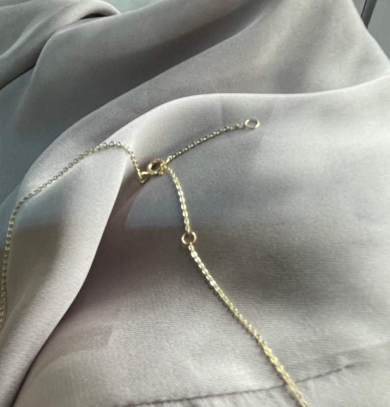 May include: A gold chain necklace with a lobster clasp closure. The chain is made of small, linked circles.
