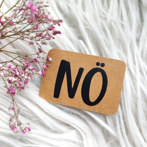 Può includere: Un cartoncino marrone con la parola "NO" scritta in lettere nere.