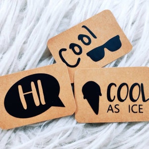 Könnte beinhalten: Drei braune Papierkarten mit schwarzem Text und Grafiken. Die erste Karte sagt "HI" in einer Sprechblase. Die zweite Karte sagt "Cool" mit einer Sonnenbrille. Die dritte Karte sagt "Cool as Ice" mit einem Eis am Stiel.