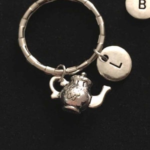 May include: Silver key chain with a teapot charm and five silver letter charms. The letters are A, B, C, D, and L. The text "Type 1" is written in red on a black background.
