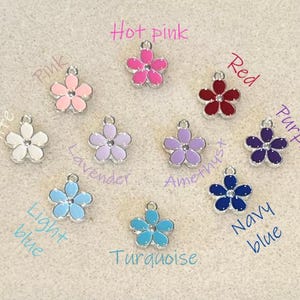 May include: Assortment of 10 flower charms in various colors, including white, hot pink, pink, lavender, amethyst, red, purple, light blue, turquoise, and navy blue.