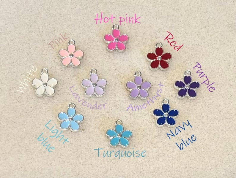 May include: Assortment of 10 flower charms in various colors, including white, hot pink, pink, lavender, amethyst, red, purple, light blue, turquoise, and navy blue.
