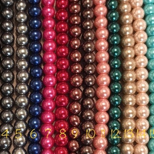 May include: Eighteen strands of pearl beads in various colors, including white, black, gray, blue, pink, red, brown, green, turquoise, and purple. The beads are numbered 1 through 18.
