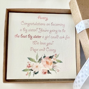 May include: A card with a floral design and the text "Avery. Congratulations on becoming a big sister! You're going to be the best big sister a girl could ask for. We love you! Pope and Casey."