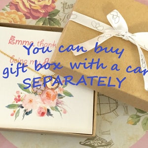 May include: A white card with a gold necklace and floral design. The card says "You can buy a gift box with a card separately".