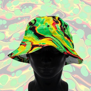 May include: A green, yellow, and black bucket hat with a swirl pattern. The hat is on a mannequin head.