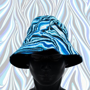 May include: A blue and black patterned bucket hat. The hat features a swirling design in shades of blue and black, set against a white background. The hat is displayed on a black mannequin head.