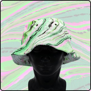 May include: A green and pink bucket hat with a marbled pattern. The hat is made of a soft, lightweight fabric and has a wide brim.