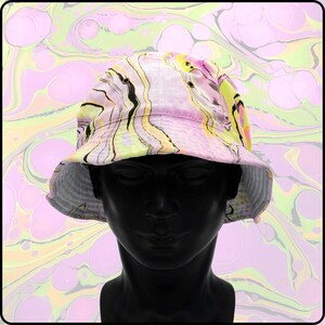 May include: A pink, yellow, and black bucket hat with a marbled pattern. The hat is on a mannequin head.
