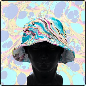 May include: A blue, pink, yellow, and white bucket hat with a marbled pattern. The hat is on a mannequin head.