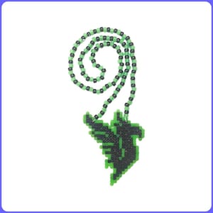 May include: A beaded necklace featuring a pendant in the shape of a stylized bird or dragon. The pendant is black and green, and the necklace is made of green and black beads. The necklace is displayed against a white background.