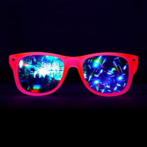May include: Pink neon sunglasses with iridescent lenses. The lenses reflect a rainbow of colors and the text "Liquid" is visible in the left lens.