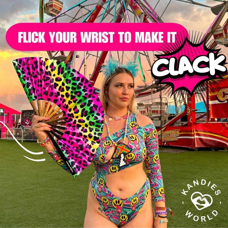 K&ouml;nnte beinhalten: Eine Frau tr&auml;gt einen bunten Badeanzug mit Smiley-Muster und einen Handf&auml;cher mit Leopardenmuster. Der Text "FLICK YOUR WRIST TO MAKE IT CLACK" wird &uuml;ber ihrem Kopf angezeigt. Der Hintergrund ist ein Karnevalssetting mit einem Riesenrad.