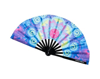 May include: A handheld folding fan featuring a vibrant, multicolored fractal pattern in shades of blue, purple, pink, and yellow. The fan has black ribs and a black handle with the white text KANDIES WORLD printed on the lower right side.
