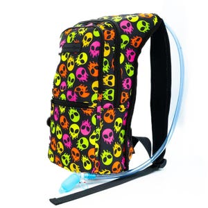 May include: A black hydration backpack with a neon green, pink, and orange alien skull pattern. The backpack has a clear tube for drinking water.