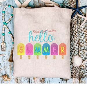 May include: A beige tote bag with the text "SewCute4Cuddles hello summer" embroidered on it. The word "summer" is spelled out with colorful popsicle-shaped letters.
