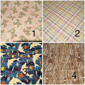 May include: Four fabric swatches with different patterns. Top left: pink fabric with gray bunnies and white flowers. Top right: plaid fabric in pink, yellow, and brown. Bottom left: blue fabric with white dolphins and colorful fish. Bottom right: brown wood grain pattern.