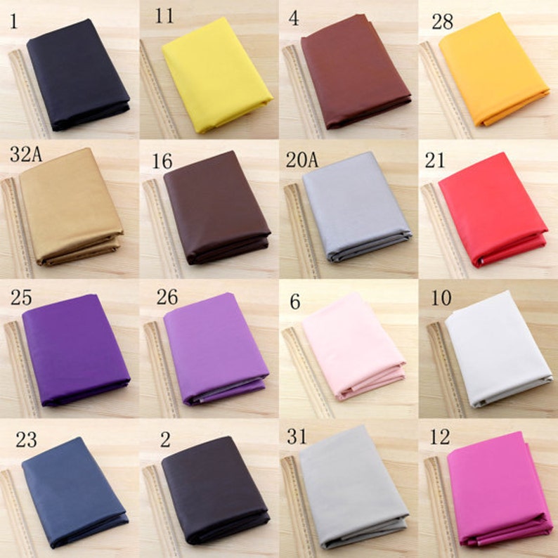 Puede incluir: Una colecci&oacute;n de 16 muestras de tela en varios colores, incluyendo negro, amarillo, marr&oacute;n, dorado, rojo, morado, rosa, blanco, gris, azul y rosa. Cada muestra est&aacute; etiquetada con un n&uacute;mero o una combinaci&oacute;n de letras.