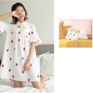 May include: A white cotton nightgown with a strawberry print. The nightgown has a mandarin collar and short sleeves.