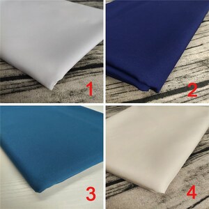 May include: Four fabric swatches in different colors: white, navy blue, teal blue, and beige. The swatches are arranged in a grid pattern.