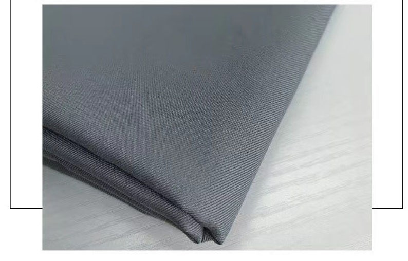 May include: Close-up of a gray fabric with a subtle texture. The fabric is folded and appears to be soft and smooth.