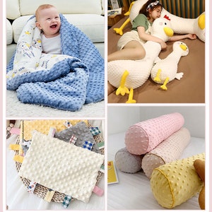 May include: A set of four baby blankets and pillows in various colours and patterns. The blankets are made of soft, textured fabric with a dotted design. The pillows are shaped like a cylinder and have a similar dotted design. The blankets and pillows are perfect for babies and toddlers.