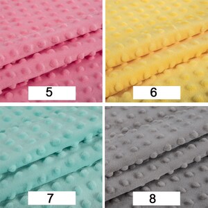 May include: Four fabric swatches with a textured dot pattern. The swatches are pink, yellow, light blue, and grey.