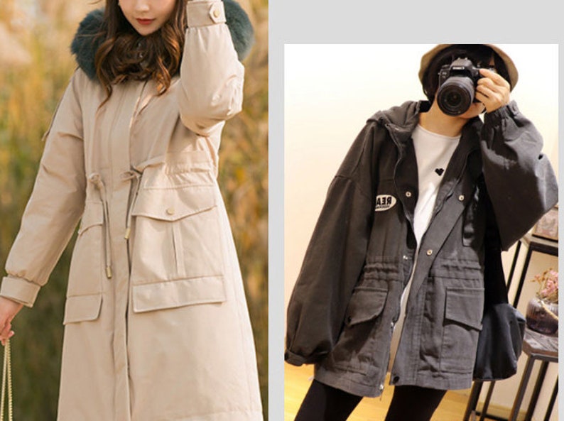 May include: Two women wearing long, hooded jackets. The jacket on the left is beige with a fur trim around the hood. The jacket on the right is black with a drawstring waist and a patch on the left sleeve that says "REAL".
