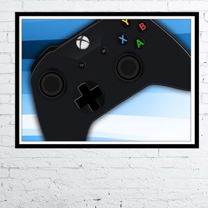 May include: A black Xbox controller with green, yellow, red, and blue buttons against a blue and white striped background.