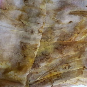 May include: A sheer fabric scarf with a brown, yellow, and pink color scheme. The fabric is wrinkled and has a natural, organic look.