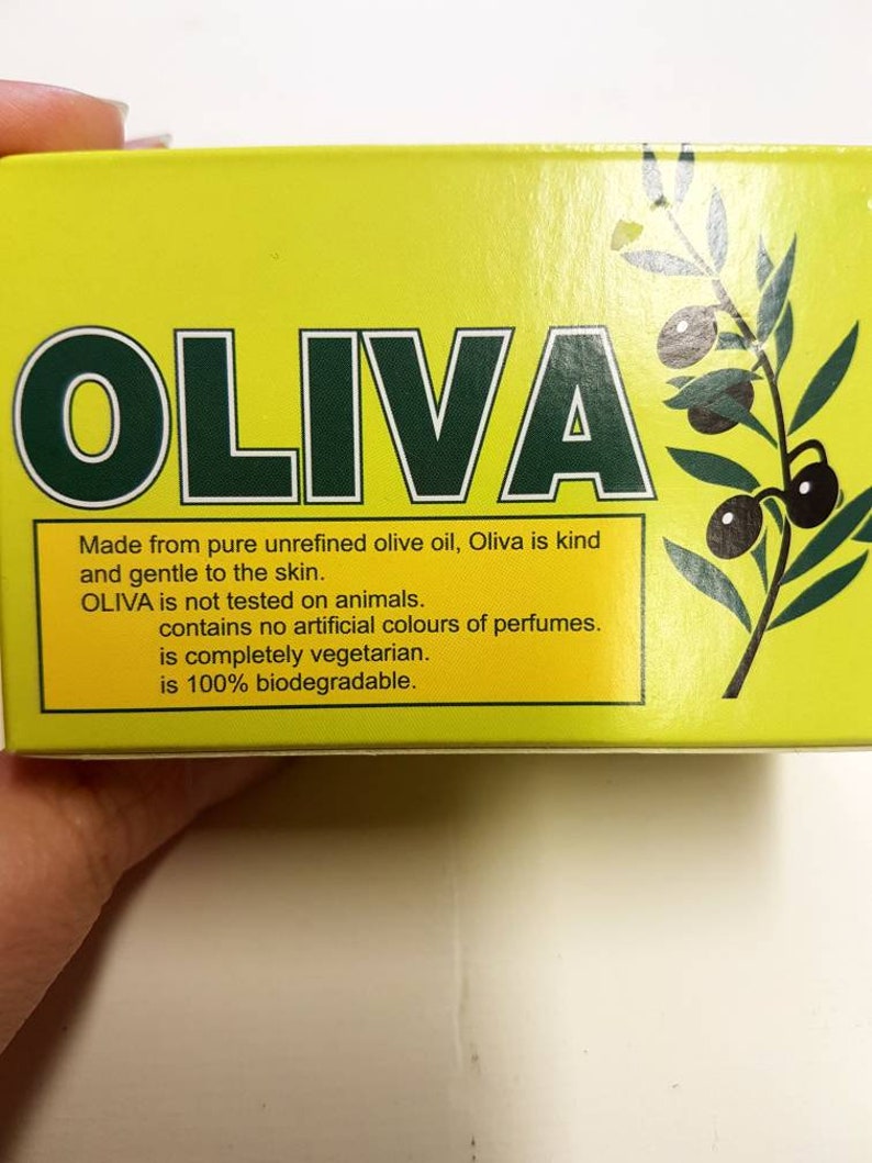 May include: Yellow box with the word "OLIVA" in green letters. The box has a picture of olive branches with olives. The text on the box reads: "Made from pure unrefined olive oil, Oliva is kind and gentle to the skin. OLIVA is not tested on animals. contains no artificial colours of perfumes. is completely vegetarian. is 100% biodegradable."