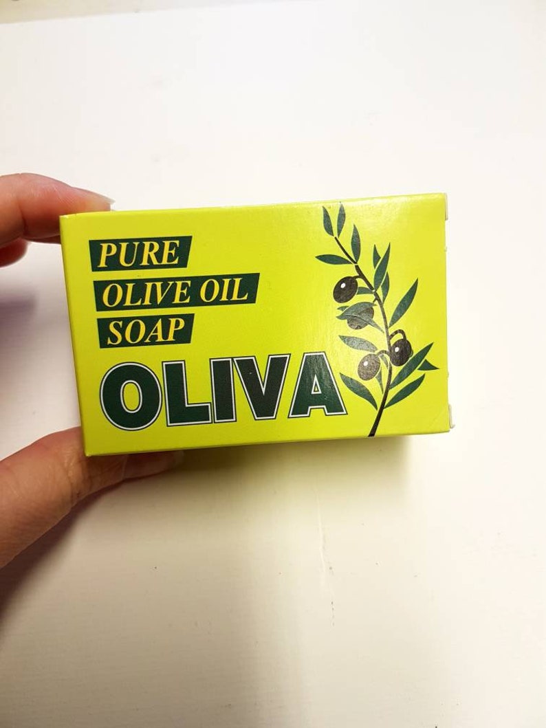 May include: A yellow box with green text and a green olive branch design. The text reads "PURE OLIVE OIL SOAP OLIVA".