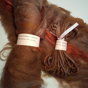 May include: Two skeins of brown and orange wool yarn. The skeins are labeled "amuk/shop/Marie ReddingArts" and "ghts Advent 2 Barney Dog".