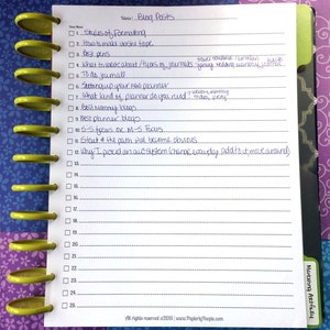 May include: A white notepad with a list of blog post ideas, including topics like formatting and journals. The notepad is bound with yellow plastic rings and sits on a patterned background.