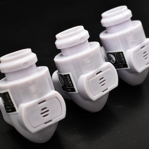 May include: Three white plastic electrical outlet covers with a black label that reads "E18243 UL LISTED", each with a small rectangular vent on the side.